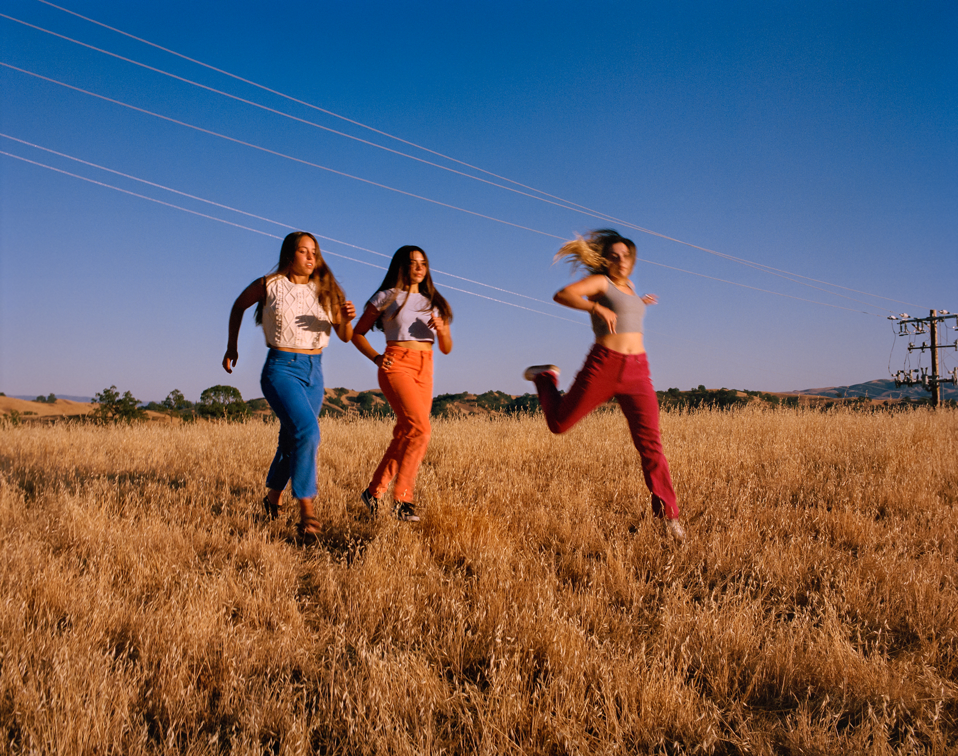 Three girls running in a field
